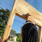 Linda Coltrane writing message on house frame